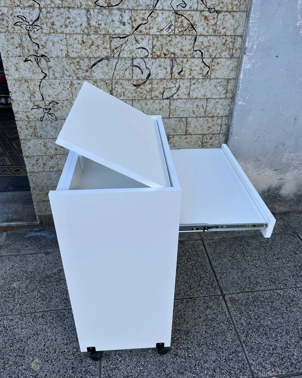 Mesa de sillón blanca con la tapa levantada y la bandeja corrediza afuera